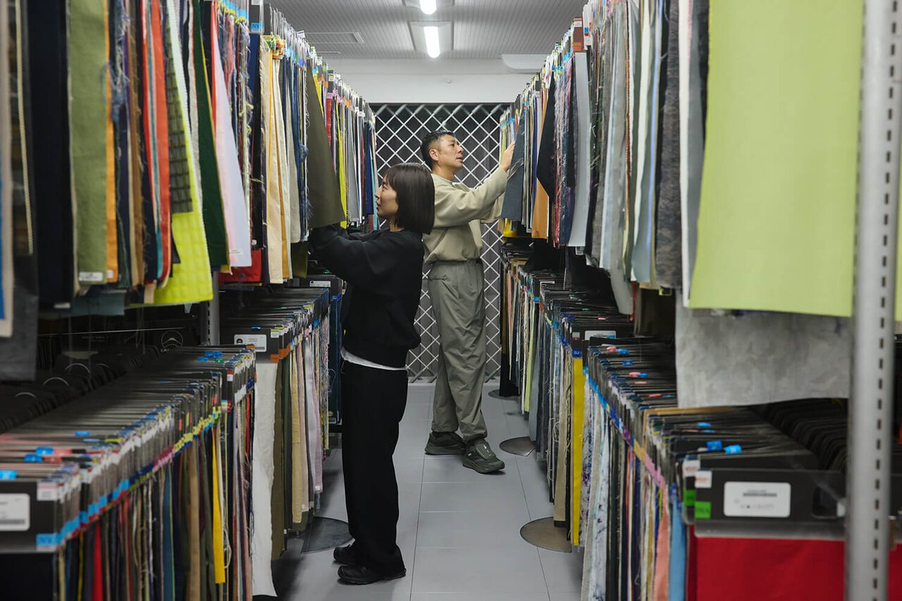 Daisuke Obana and Maiko Akimoto review fabric samples in the D.O. United Arrows archive, showcasing a wide variety of materials for design development.